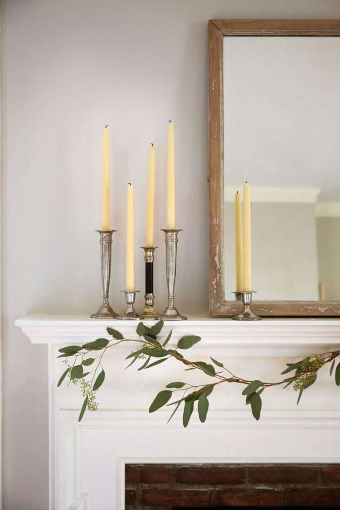 The silvery eucalyptus leaves of a gentle garland complement a grouping of sterling candlesticks with beeswax candles serving as a requisite “vertical element” while also adding a bit of bling. Learn how to create this with tips from the Gardenista. 