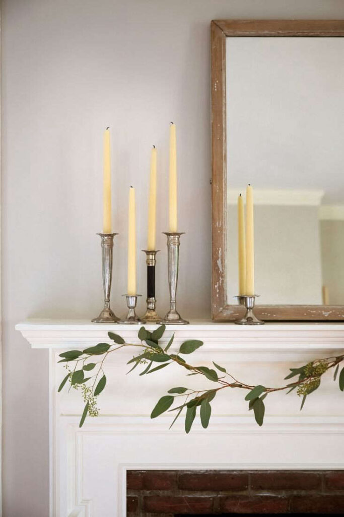 The silvery eucalyptus leaves of a gentle garland complement a grouping of sterling candlesticks with beeswax candles serving as a requisite “vertical element” while also adding a bit of bling. Learn how to create this with tips from the Gardenista.